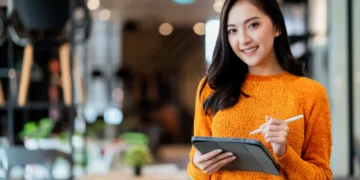 confianca-inteligente-empreendedora-de-inicializacao-feminina-asiatica-proprietaria-de-pequenas-empresas-empresaria-usar-pano-casual-inteligente-sorriso-uso-de-mao-tablet-merchandising