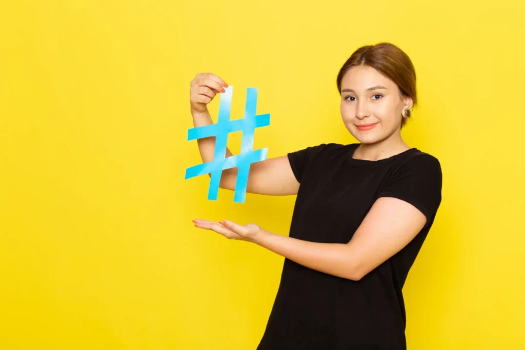 uma-jovem-mulher-de-vestido-preto-segurando-uma-hashtag-azul-sorrindo-em-amarelo-hashtags para tiktok